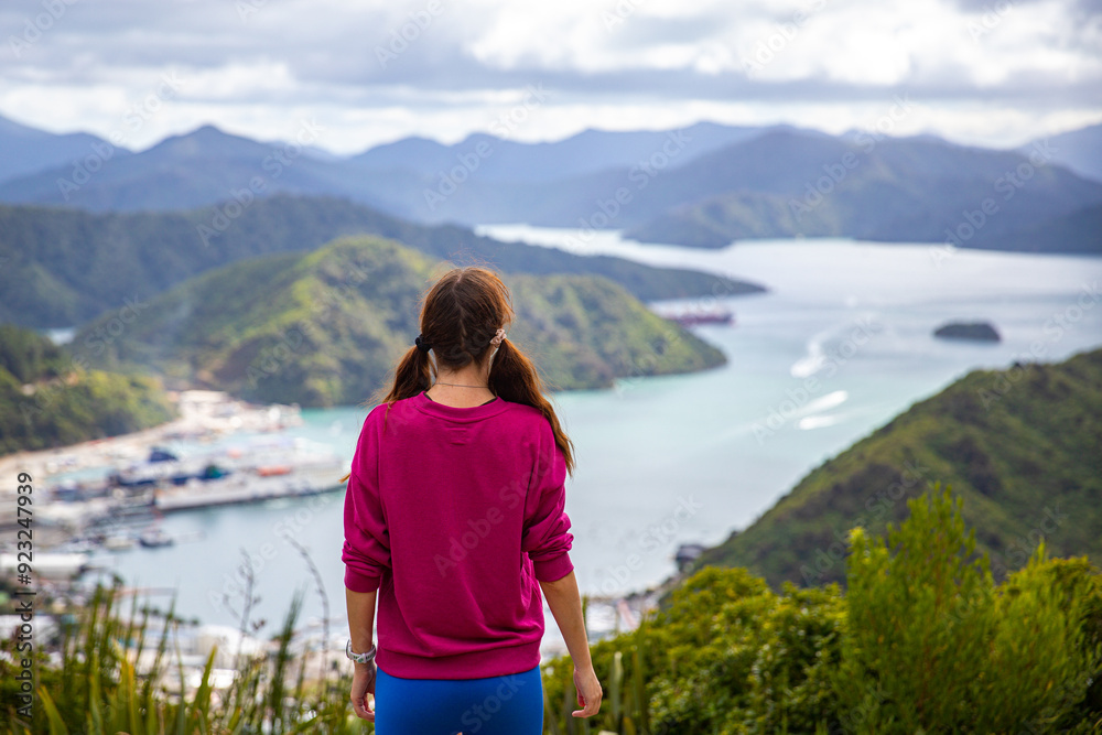 hiker girl enjoys the panorama of picton harbour seen from tirohanga track; new zealand south island hiker girl enjoys the panorama of picton harbour seen from tirohanga track; new zealand south island
