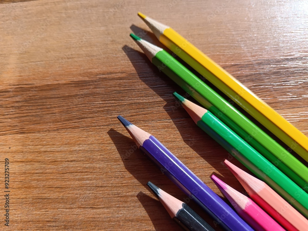 pencils on brown wooden background 