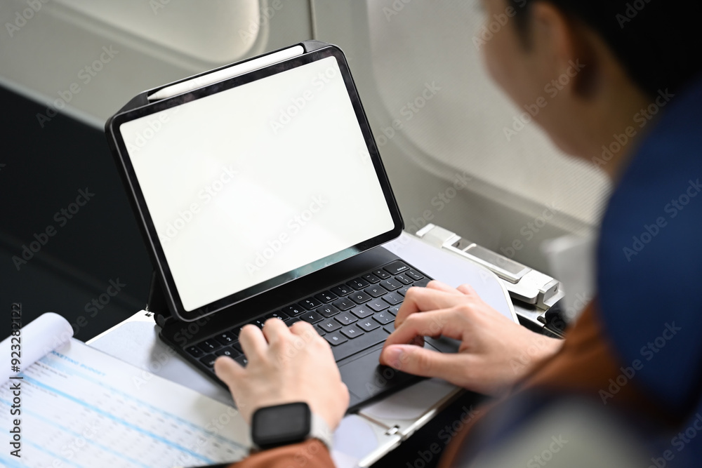 Close up shot businessman using digital tablet and working with documents during flight Close up shot businessman using digital tablet and working with documents during flight