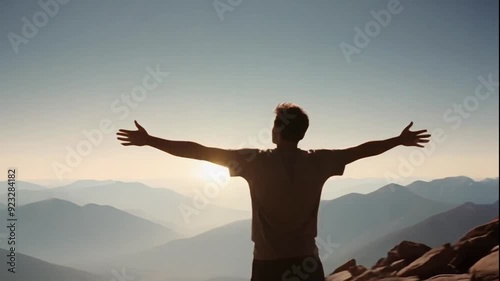 Loop of reaching the top of the mountain and success, a man with his arms outstretched feeling great looping video