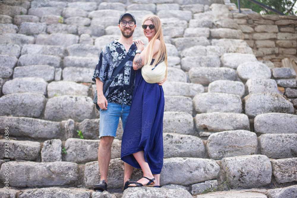 romantic tourist couple in complex of mayan pyramids with wide impressive steep stairs in ancient city lost in the tropical jungle of Yucatan romantic tourist couple in complex of mayan pyramids with wide impressive steep stairs in ancient city lost in the tropical jungle of Yucatan