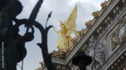 Golden sculpture presiding over a side of the facade of the Paris opera house.