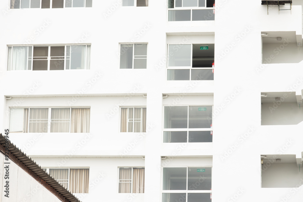 A white building with many windows and a green sign on the side. The building is empty and has a very clean and modern look A white building with many windows and a green sign on the side. The building is empty and has a very clean and modern look
