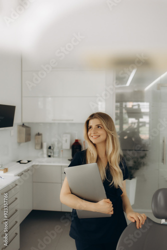 a young female dentist with a laptop in her hands