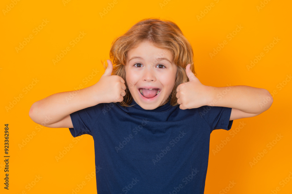 Excited child showing thumbs up on studio isolated background. Kid boy making thumbs up sign. Excited child showing thumbs up on studio isolated background. Kid boy making thumbs up sign.
