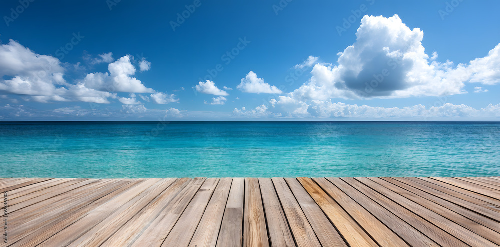 Fototapeta premium Wooden deck in front of clear blue ocean with clouds in the sky