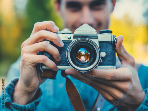 A man is holding a camera and smiling