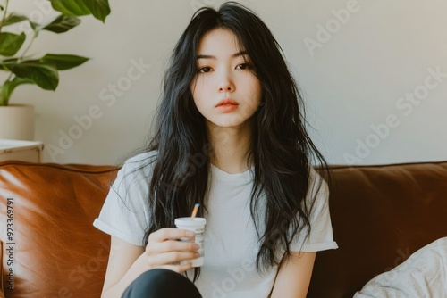 Sick pain of health. Asian woman holding a syringe, sleeping on the couch with a narcotic, depressed and despairing. Suicide despondent. photo