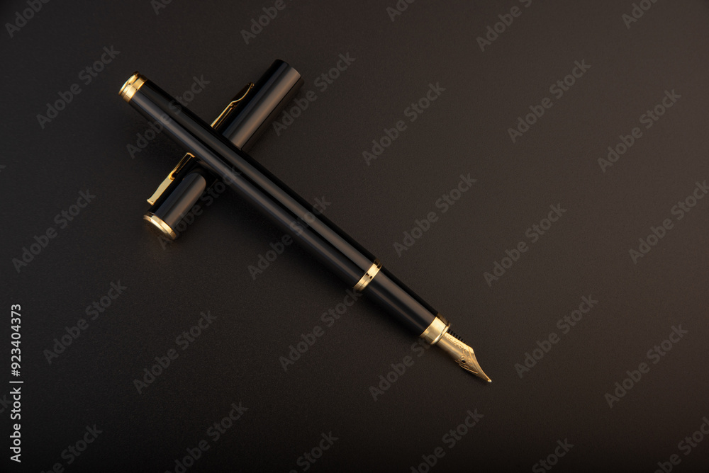Fountain pen, beautiful black and gold fountain pen, positioned on dark background, selective focus. Fountain pen, beautiful black and gold fountain pen, positioned on dark background, selective focus.