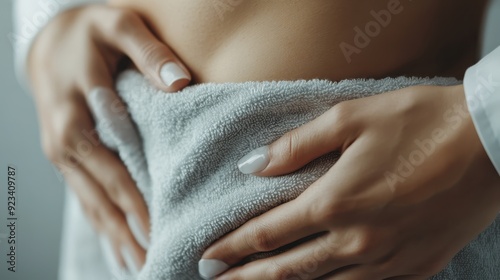 A towel-covered pregnant belly is being gently held, symbolizing the intimate bond and nurturing care given during pregnancy. Emphasis on warmth and protection. photo