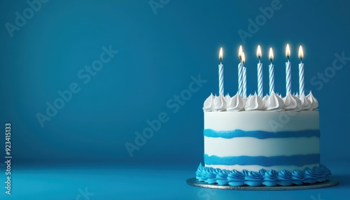 Blue cake with lit candles on a blue background celebrating a birthday