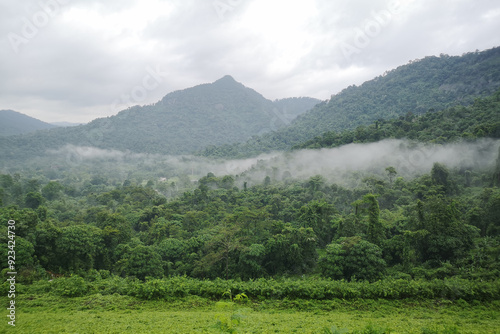 Scenic view of a mountain river flowing through a lush green forest with reflections in the water and surrounding mountains