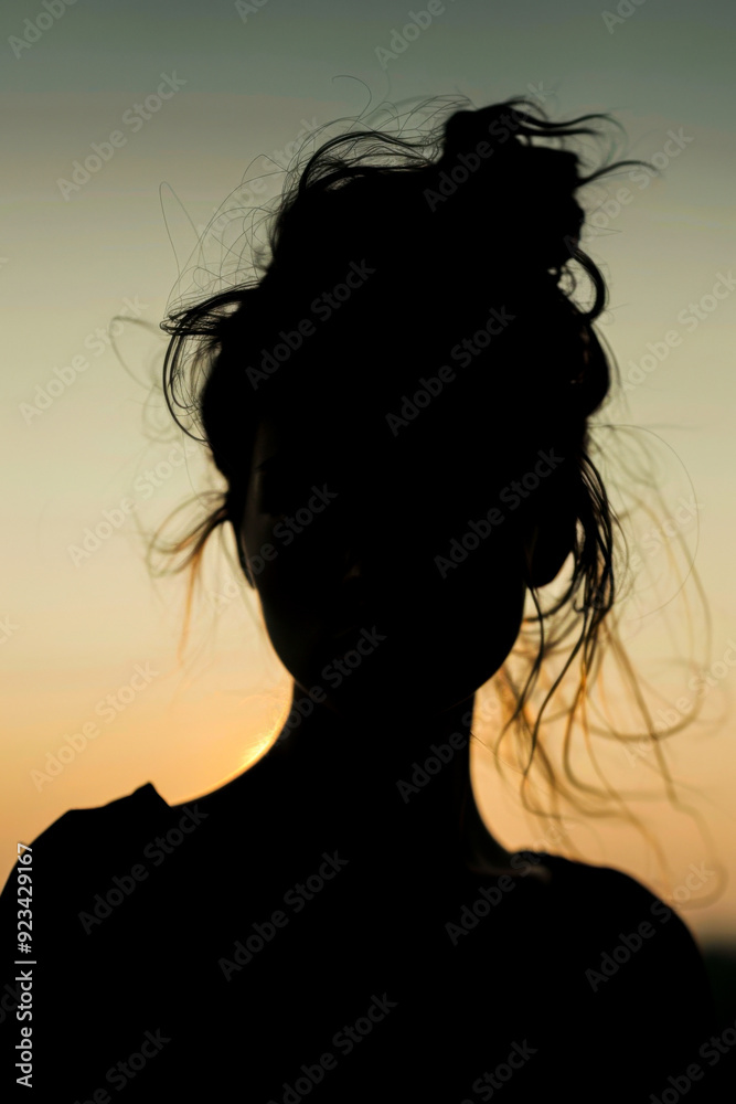 A woman with a messy bun and a serious expression A woman with a messy bun and a serious expression