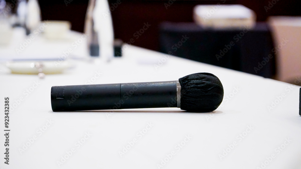 Φωτογραφία Isolated view of a microphone in a meeting room on a table with blurred chairs -