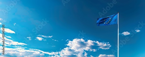 European Union Flag Waving Against a Blue Sky with Clouds