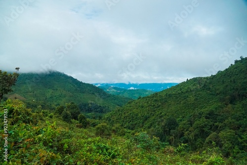 A lush green mountain range with a cloudy sky in the background