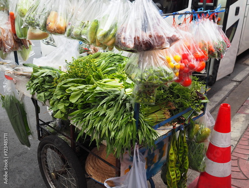 Mobile food market hang some vegetables, fruits, necessary condiments place some in vehicle. Market on wheels use a two-wheeled shopping cart that has been modified for loading to sell in community.
