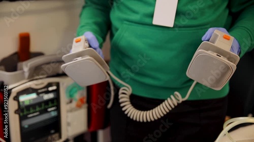 Close up of Paramedic holds defibrillator in his hands. Emergency care assistants in an ambulance. Ems paramedics team provide medical help to injured patient on the way to hospital
