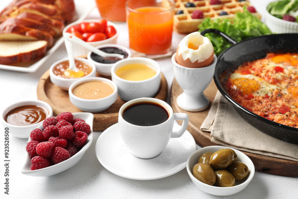 Cup of coffee and different meals served for breakfast on white table Cup of coffee and different meals served for breakfast on white table