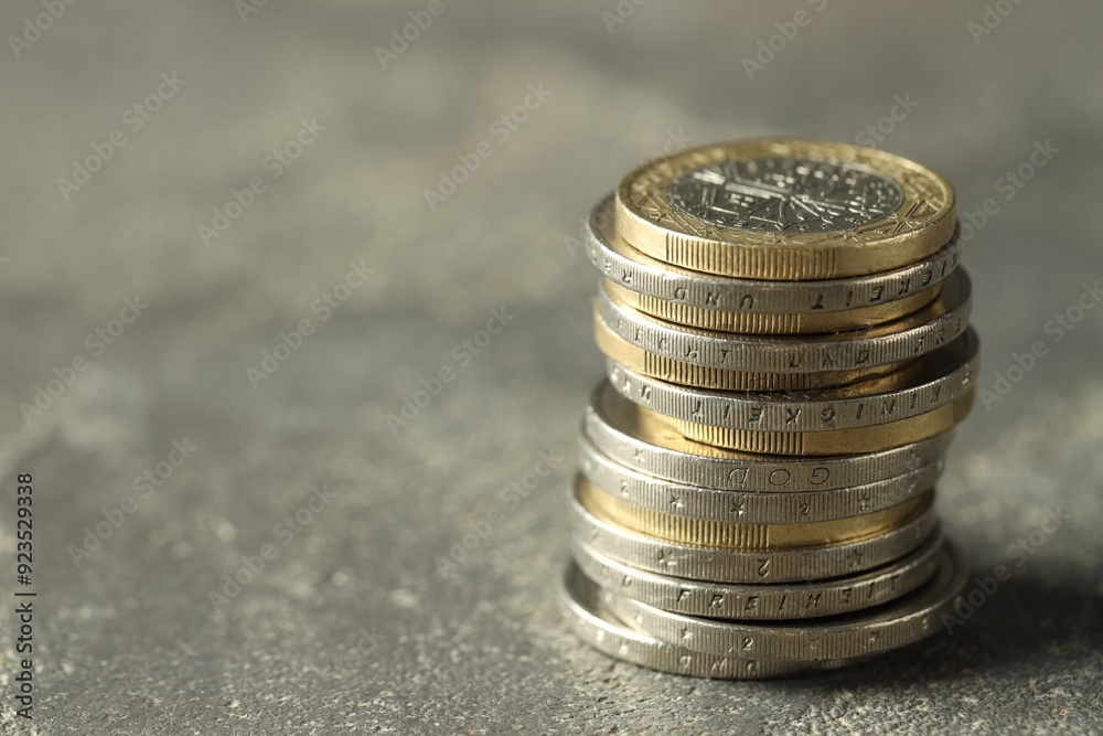 Stacked euro coins on grey table, space for text Stacked euro coins on grey table, space for text