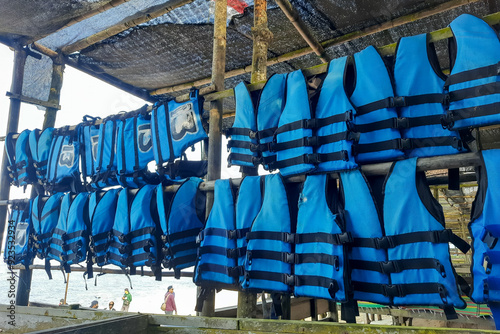 Many blue life jackets in a row for water safety. photo