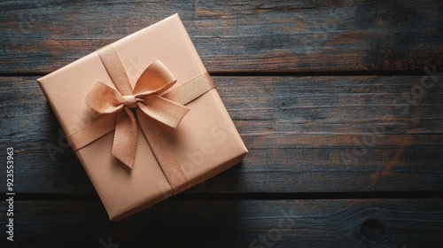 Beautifully wrapped gift box with a ribbon bow on a rustic wooden background, perfect for celebrations and special occasions.