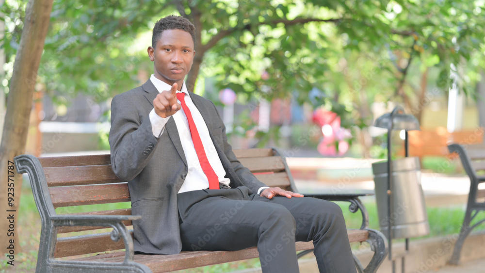 African Businessman Pointing at Camera while Sitting Outdoor African Businessman Pointing at Camera while Sitting Outdoor