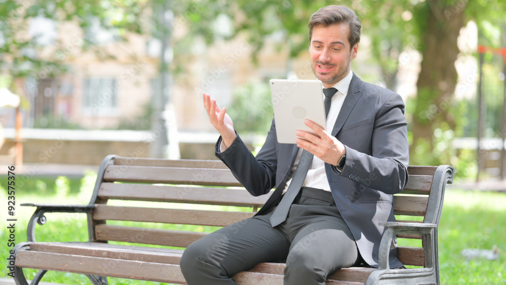 Fototapeta premium Middle Aged Businessman Doing Video Chat on Tablet Outdoor
