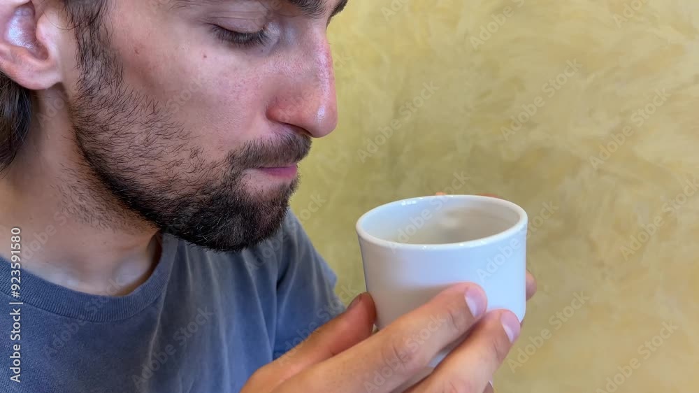Man savoring and reacting to a hot cup of coffee, experiencing various emotions and tastes in a cozy setting. Close up shot captures the rich aroma and satisfaction Man savoring and reacting to a hot cup of coffee, experiencing various emotions and tastes in a cozy setting. Close up shot captures the rich aroma and satisfaction