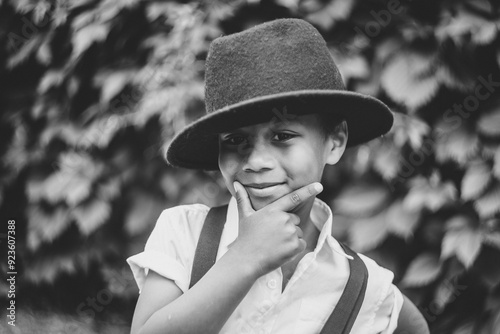 close-up portrait of a boy with a hand on his chin, a slight smile