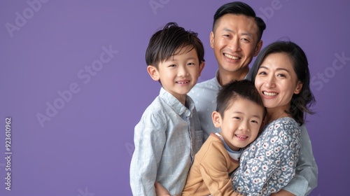 A smiling family poses together with their two young boys, showcasing their happiness and love