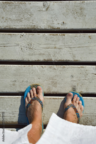 women's legs in a slate bridge made of white wooden planks. summer vacation. background for the design