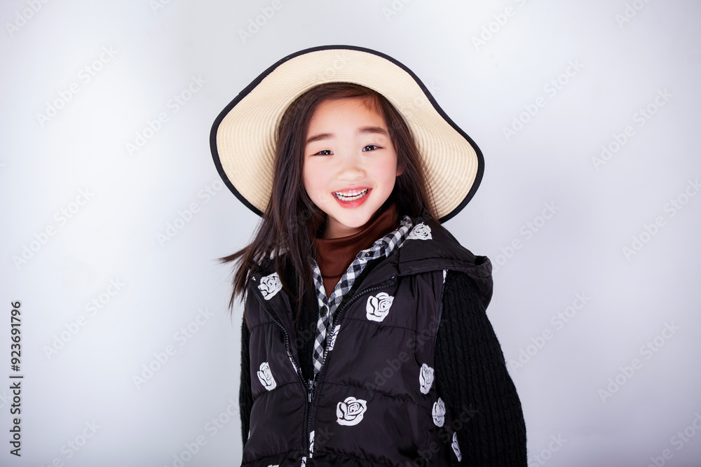 Fototapeta premium Asian little girl wearing a straw hat on white background