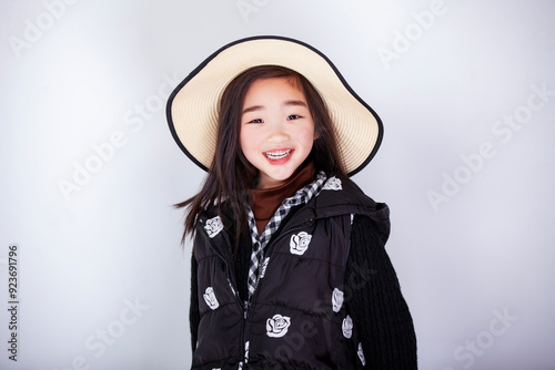 Asian little girl wearing a straw hat on white background