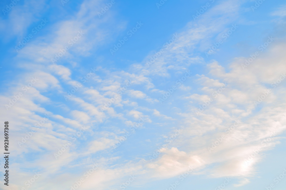 Blue sunset sky landscape with white clouds lit by evening sunset light Blue sunset sky landscape with white clouds lit by evening sunset light