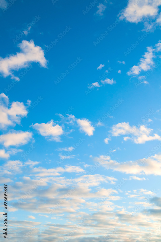 Blue sky landscape with dramatic sundown clouds lit by evening sunset light Blue sky landscape with dramatic sundown clouds lit by evening sunset light