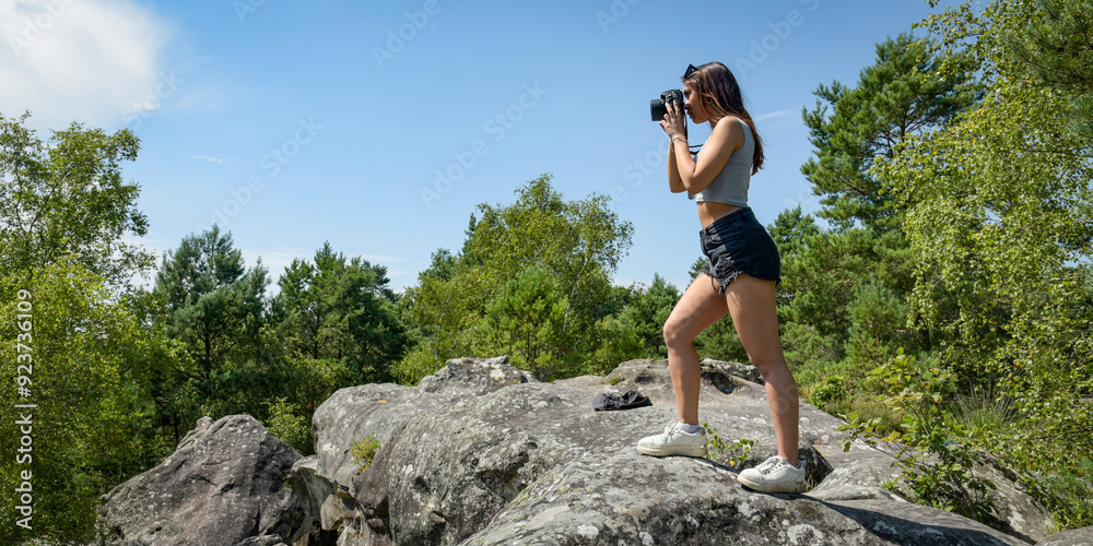 Caucasian woman taking pictures in the nature