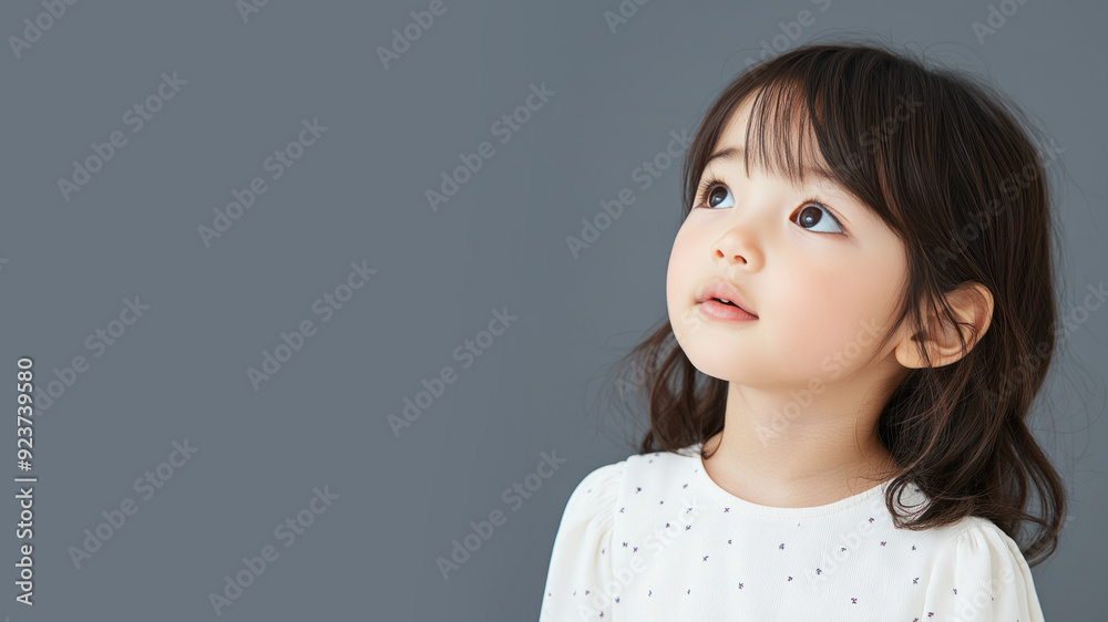 Side view of Japanese little girl wearing white dress isolated on gray Side view of Japanese little girl wearing white dress isolated on gray