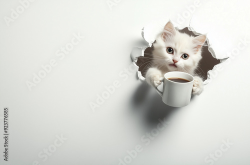 Cute white cat holding a cup of coffee, out of torn wallpaper hole photo