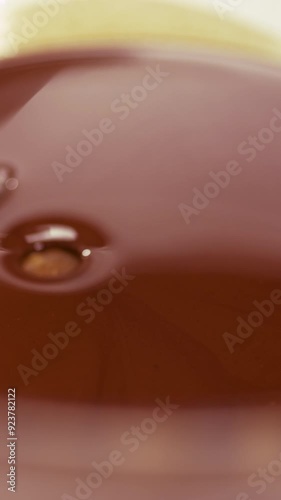 Confectioner glazing caramel candy with crushed nuts in melted chocolate photo