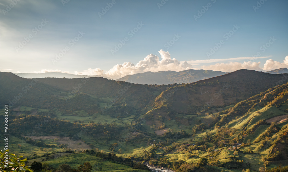 Fototapeta premium Expansive Mountain Valley View with Rolling Hills and Cloudy Sky, Nature and Tranquility Concept, Scenic Countryside Landscape at Sunset