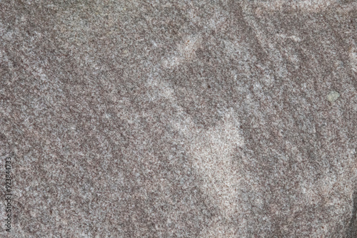 Close up photo of a granulated rock texture. The rock contains whites, gray, and silver. With copy space. photo