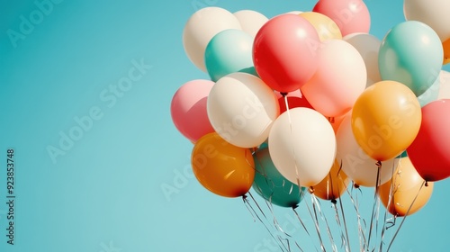 This image shows a vibrant bundle of colorful balloons rising gracefully into a clear blue sky, symbolizing celebration, joy, and freedom, and creating a cheerful atmosphere. photo