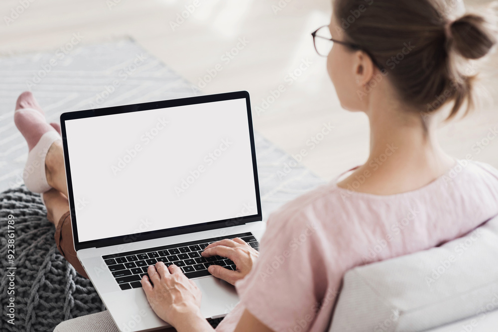 Young woman using laptop computer at home. Blank empty white screen mock up. Freelance, student lifestyle, education, web conference, video call, technology and online shopping concept Young woman using laptop computer at home. Blank empty white screen mock up. Freelance, student lifestyle, education, web conference, video call, technology and online shopping concept