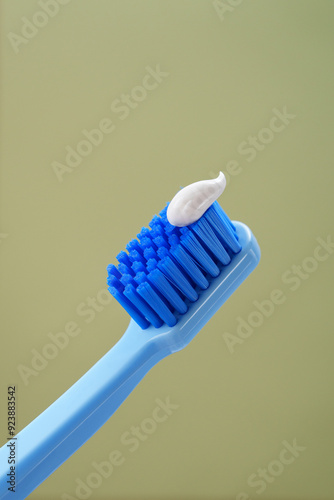 Mint background. Blue toothbrush with toothpaste on a green background, close-up.