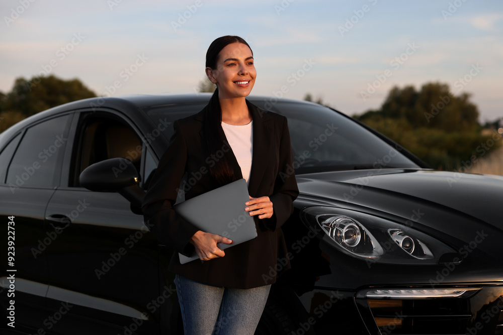 Happy young woman with laptop near car outdoors Happy young woman with laptop near car outdoors