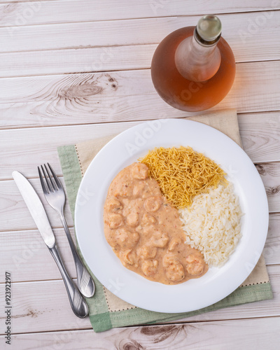 Shrimp strogonoff with rice and straw potato over wooden table photo