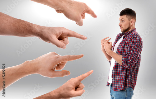 People pointing at man on grey background. Failure, responsibility, social pressure