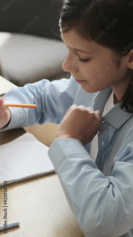 Concentrated young Caucasian boy writing math exercise in notebook at home. Homework, learning and education concept. Vertical video. Concentrated young Caucasian boy writing math exercise in notebook at home. Homework, learning and education concept. Vertical video.