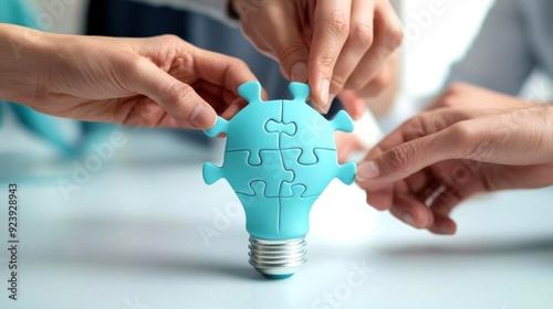 Hands assembling a blue puzzle piece shaped like a light bulb, symbolizing creativity and teamwork to solve problems. photo